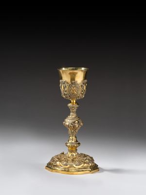 a gold plated chalicet with a floral design on the base