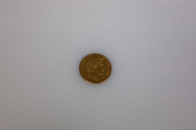gros plan d'une pièce d'or sur une surface blanche