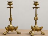 pair of antique brass candlesticks sitting on top of a wooden table