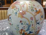 a white vase with colorful designs on it on a table