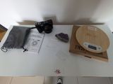 une table blanche sur laquelle se trouvent un appareil photo, un sac et d'autres objets