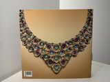 a gold and purple necklace sitting on top of a white table
