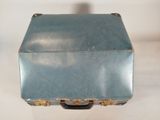 a small blue suitcase sitting on a white surface