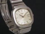 a silver watch that is sitting on a black surface