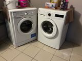 two washers and a dryer in the corner of a room