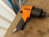 une perceuse électrique orange et noire posée sur une table
