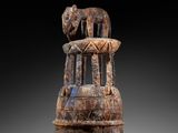 an image of a wooden sculpture of a horse on top of a tower