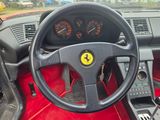 steering wheel of a red sports car with gauges and gauges