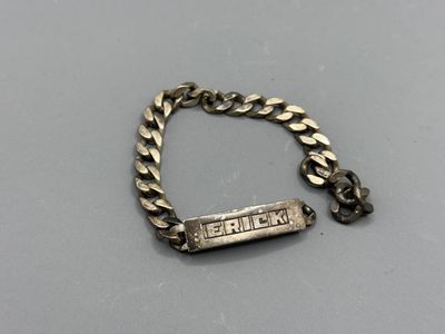 a close up of a silver bracelet with a nameplate on it