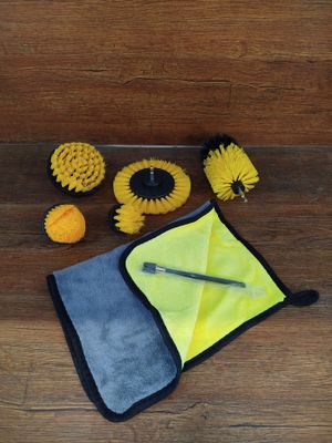 un gros plan sur un kit de nettoyage jaune et noir posé sur un parquet