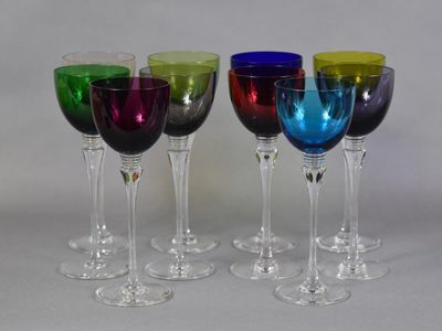four wine glasses are lined up in a row on a table
