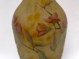 a yellow vase with flowers painted on it on a white background