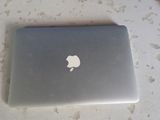 an apple laptop sitting on a table next to a box