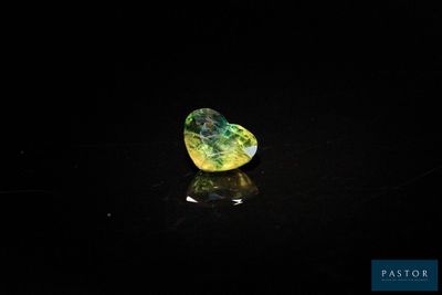 un losange jaune et vert sur un fond noir