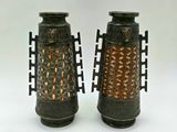 two vases sitting side by side on a white surface