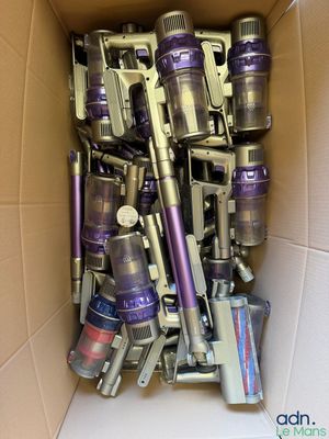 une boîte remplie d'aspirateurs et d'autres produits d'entretien