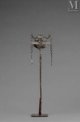 a silver sculpture of a bird on top of a pole