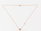 un collier en or avec un pendentif en diamant sur fond blanc