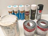 many cans of paint and cans of paint on the table