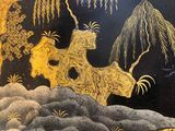 a black and gold plate with a painting on it
