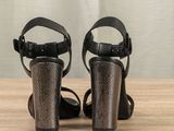 pair of black high heeled sandals sitting on top of a wooden table