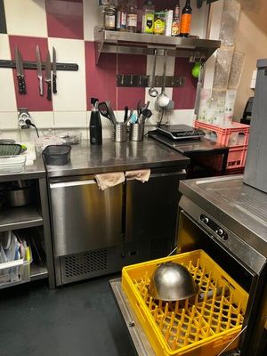 un lave-vaisselle au milieu d'une cuisine, avec un panier jaune à l'intérieur