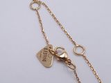 a close up of a gold chain with a heart charm on it