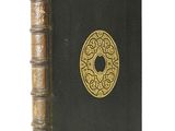 a black book with gold trim and a gold medallion on the cover