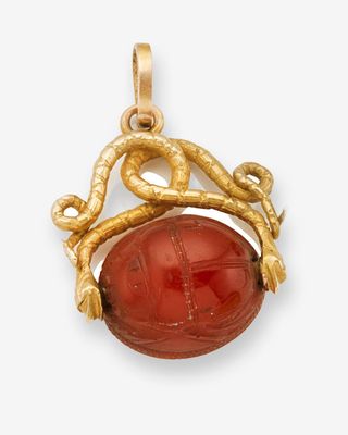 un pendentif en or et en cornaline orné d'un serpent