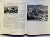 an open book on a table with a picture of a factory
