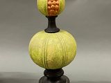 pair of green and yellow lamps with a black base on a gray background