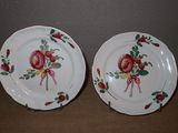 deux assiettes avec des fleurs peintes dessus, posées sur une table