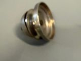 a silver object on a table with a white background