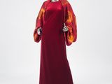 a woman ' s red dress with orange and yellow print on the sleeves