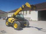 a picture of a yellow tractor parked in front of a building