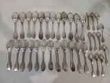 un grand nombre de cuillères et de fourchettes en argent disposées sur une table