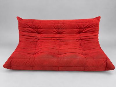 a red futon sofa with a red cushion on it