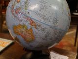 un globe terrestre posé sur une table dans une pièce aux murs rouges