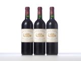 three bottles of wine are lined up on a table