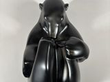 sculpture of a black bear holding a boxing glove on a white background