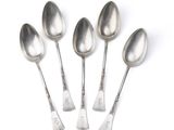 four spoons are lined up in a row on a white surface