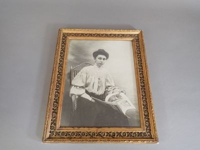 an old picture of a woman sitting in a chair