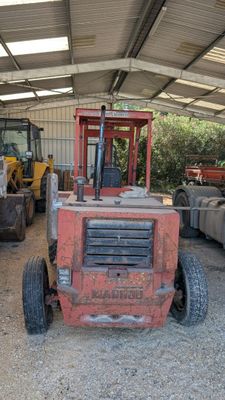 un tracteur rouge garé dans un garage avec d'autres véhicules
