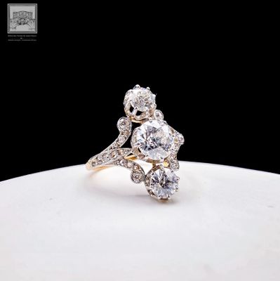 an image of a diamond and gold ring on a white plate