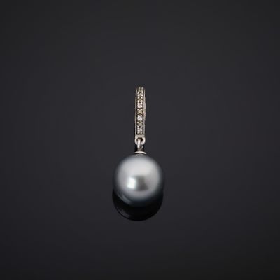 une image représentant un pendentif composé d'une perle noire et de diamants, sur fond noir