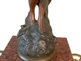 bronze statue of a woman holding a bird on top of a marble base