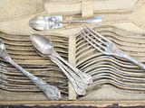 de nombreuses cuillères, rangées dans une boîte posée sur la table