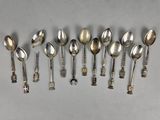 six silver spoons are lined up in a row on a table
