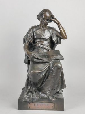 a statue of a woman sitting on a chair with her hand on her head