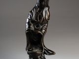 an image of a statue of a woman sitting on a stool